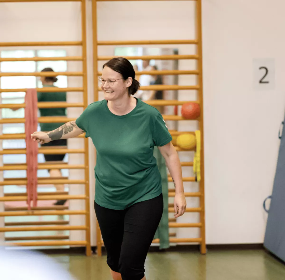Eine Frau macht eine Reha-Übung vor Sprossenwand – gezielte Bewegungstherapie in der stationären Reha.
