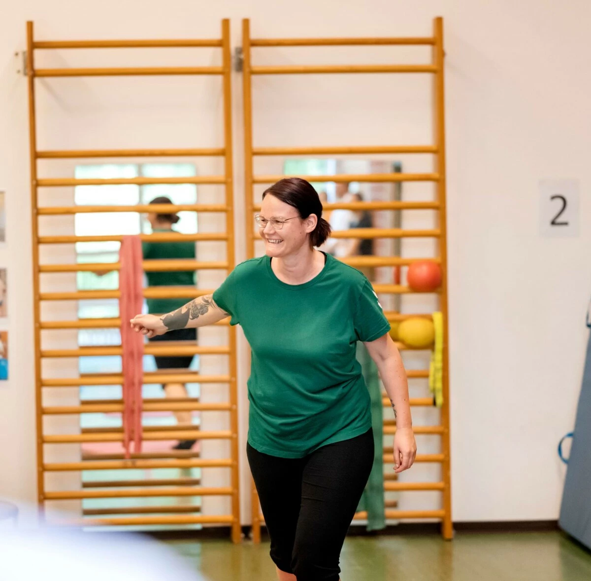 Eine Frau macht eine Reha-Übung vor Sprossenwand – gezielte Bewegungstherapie in der stationären Reha.