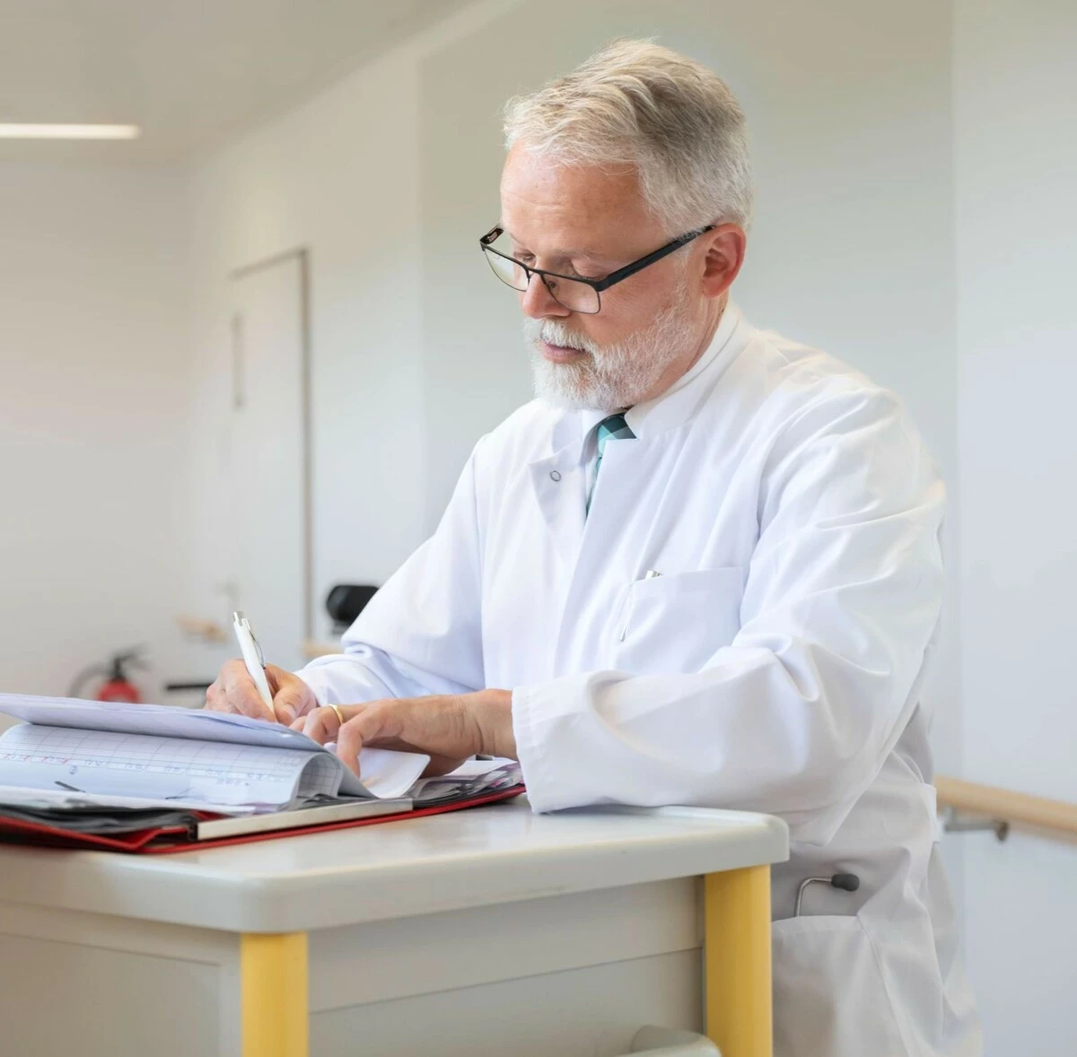 Arzt dokumentiert in der Akte auf dem Klinikflur.