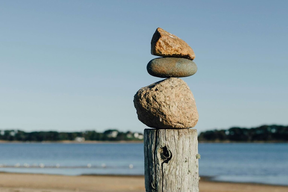 Ein Turm sorgfältig aufeinandergestapelter Steine am Strand, die in Balance stehen