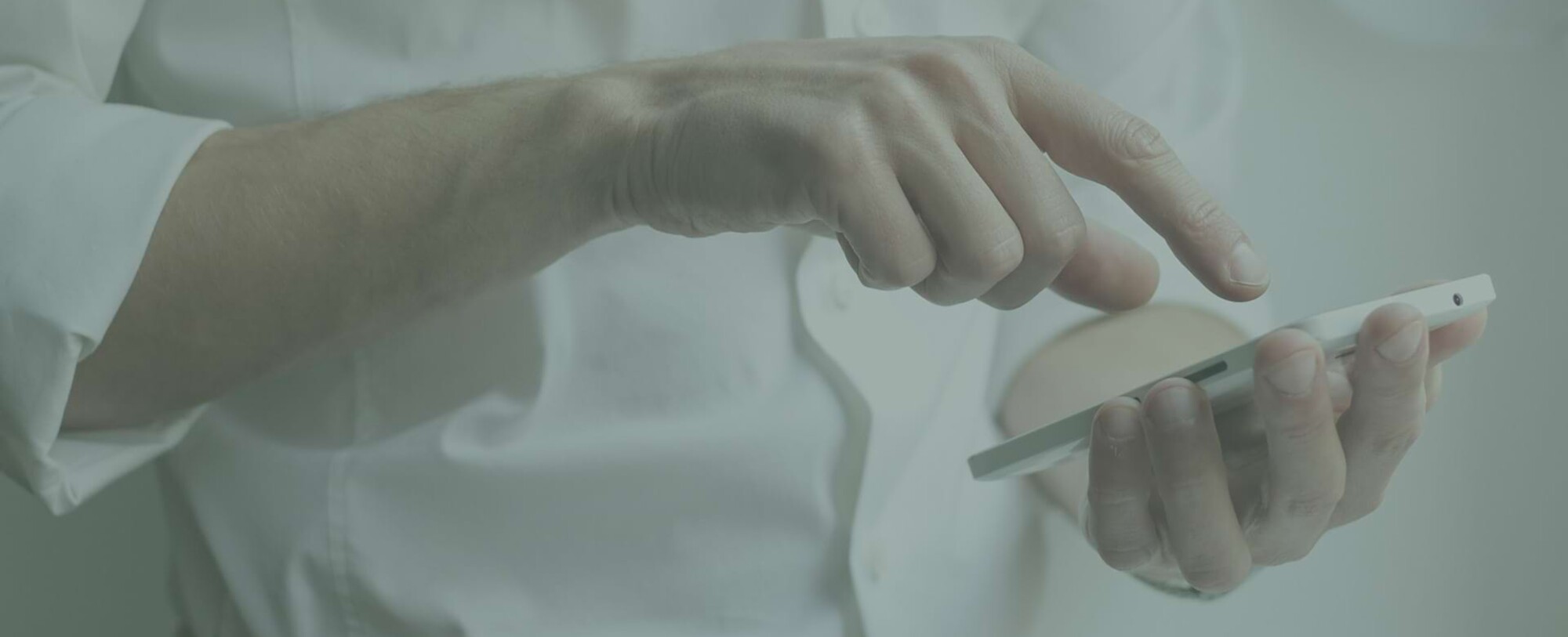 Detailaufnahme einer Person, die ein Smartphone in der Hand hält und etwas eintippt.