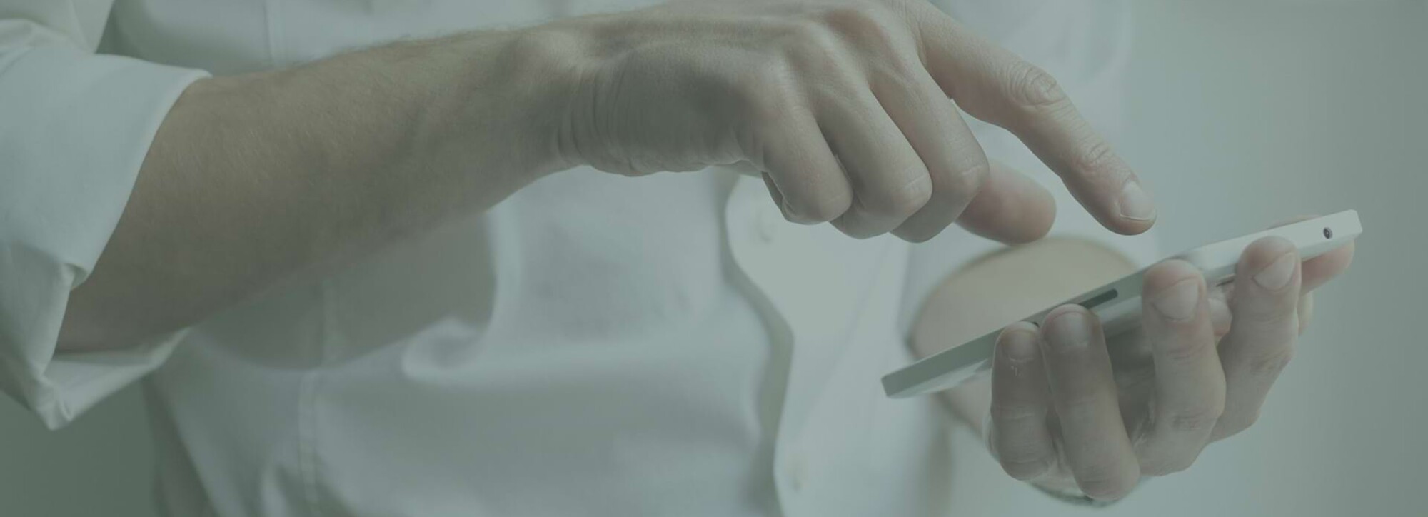 Detailaufnahme einer Person, die ein Smartphone in der Hand hält und etwas eintippt.